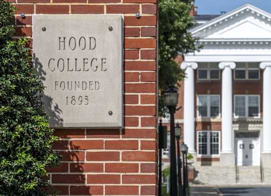 A sign on a brick wall that says Hood College Founded 1893.