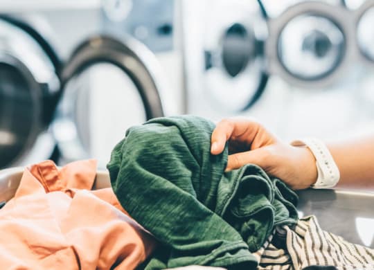 a woman washing clothes in a laundry room