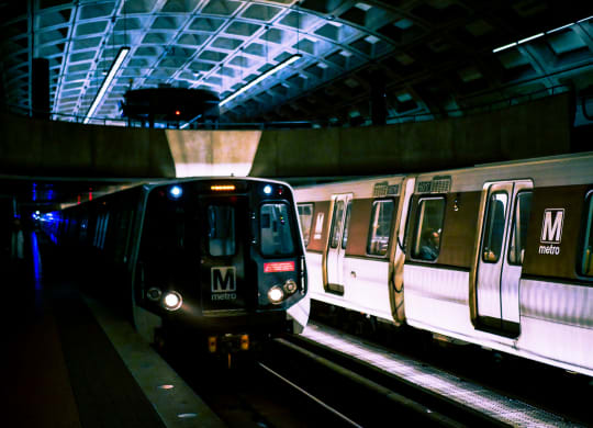 a subway train pulling into a subway station at night