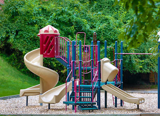 a playground with a slide and other toys in a park