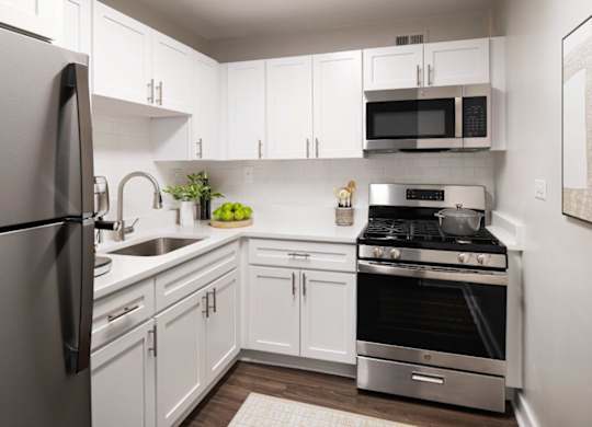 A modern kitchen with white cabinets and stainless steel appliances.