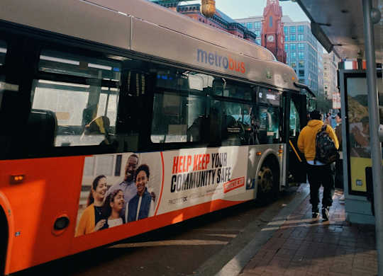 a bus is parked at a bus stop in front of a pagoda