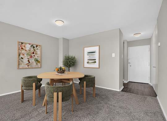 A dining room with a round table and chairs.