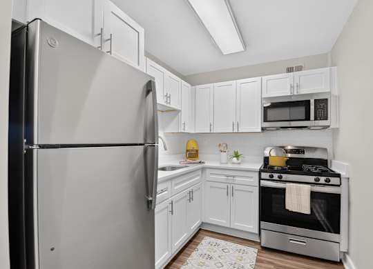 A modern kitchen with a stainless steel refrigerator and oven.