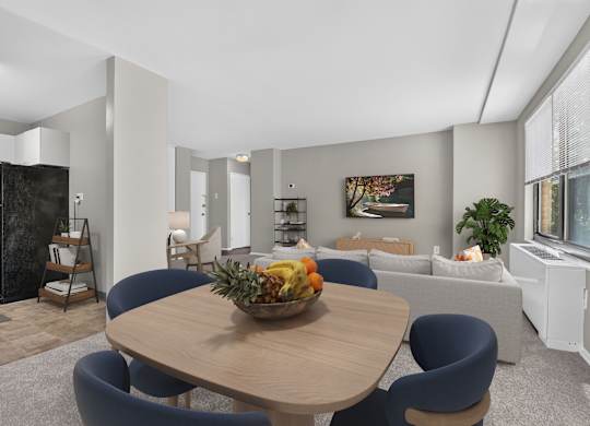 A modern dining room with a wooden table and blue chairs.