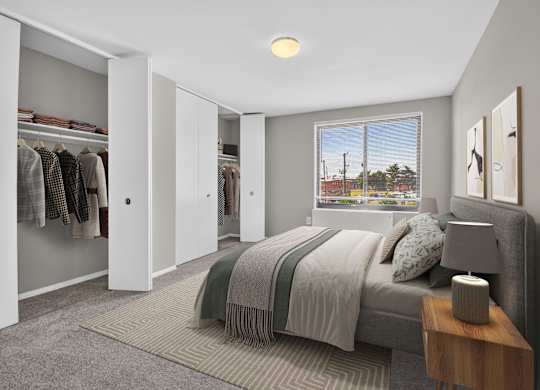 A bedroom with a bed, a nightstand, and a wardrobe.