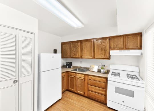 a kitchen with white appliances and wooden cabinets