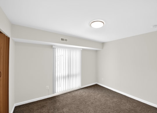 an empty room with white walls and a window