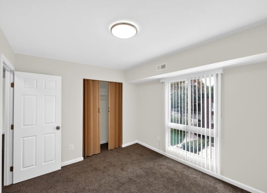 a bedroom with a large window and a white door