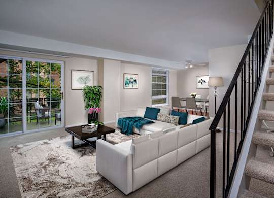a living room with a white couch and a staircase