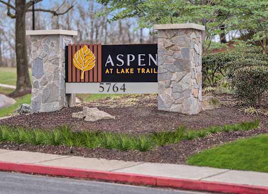 A sign for Aspen at Lake Trail with a phone number on it.
