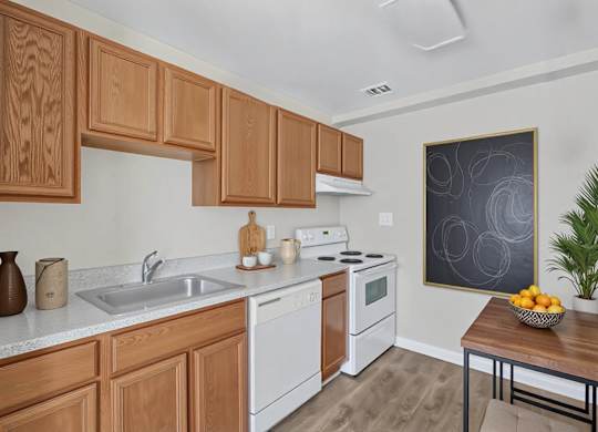 Kitchen with wood cabinets and white appliances at Highland Ridge Apartments, Capitol Heights