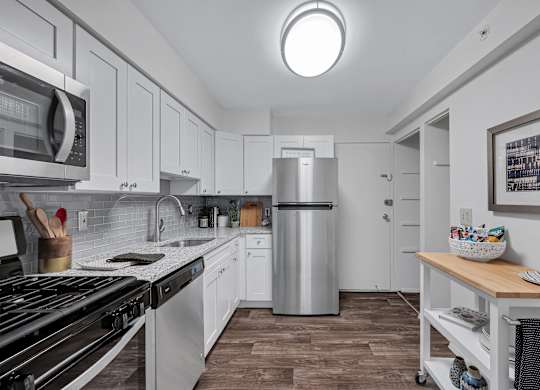 Kitchen with white cabinets and a stainless steel refrigerator at Aspen at Lake Trail, Columbia