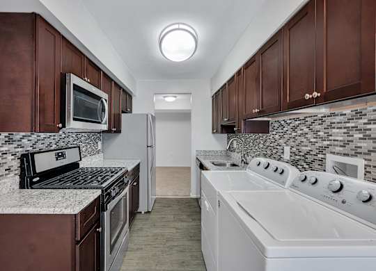 Kitchen With White Cabinetry And Appliances at Aspen at Lake Trail, Columbia, MD 21045