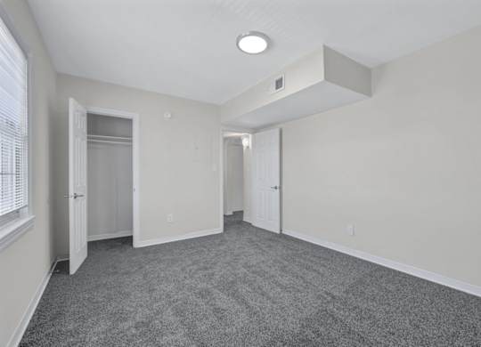 Empty bedroom with walk-in closet and carpet at Highland Ridge Apartments, Capitol Heights, MD