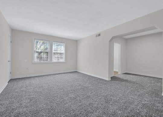 Spacious living room with carpeting and alcove at Highland Ridge Apartments, Capitol Heights, 20743