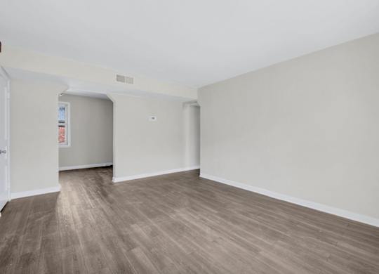 Empty living and dining space with woodstyle flooring at Highland Ridge Apartments, Capitol Heights, 20743