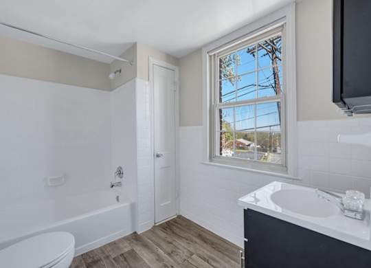 Bathroom with white tub and vanity at Highland Ridge Apartments, Capitol Heights, Maryland