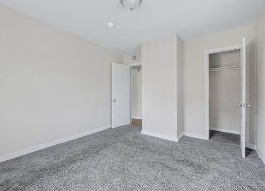 Empty bedroom with gray carpet and builtin closet at Highland Ridge Apartments, Maryland