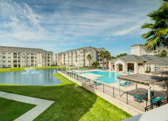 a swimming pool with a fountain and a gazebo in front of a building  at Century Avenues, Florida, 33813