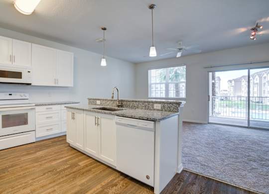 a kitchen and living room with a sliding glass door to a balcony  at Century Avenues, Lakeland, Florida