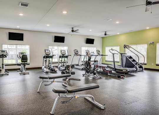 a gym with treadmills and other exercise equipment at Century Belmont Station, Louisville, 40243