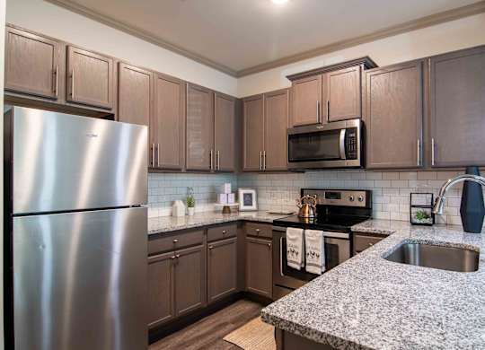 a kitchen with stainless steel appliances and granite counter tops at Century New Holland, Gainesville, Georgia