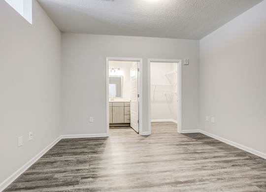 a bedroom with gray walls and a wooden floor at Century University City, Charlotte, 28213