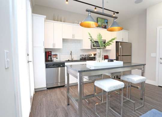 A modern kitchen with a stainless steel dishwasher and refrigerator.at Century Baxter Avenue, Louisville, KY 40204