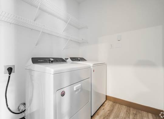 A white washing machine and dryer in a laundry room. at Century Belmont Station, Louisville, KY