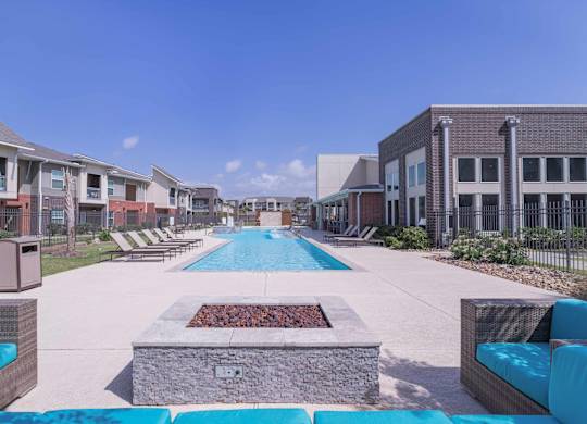 our apartments have a large pool with lounge chairs and a fire pit at Century Palm Bluff, Portland, TX