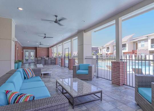 a patio with couches and chairs and a pool at Century Palm Bluff, Portland, 78374