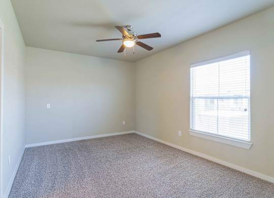 an empty room with a ceiling fan and a window at Century Palm Bluff, Portland, Texas