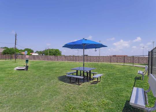 a picnic table with an umbrella in a yard at Century Palm Bluff, Portland, TX
