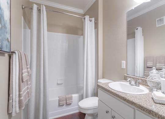 a bathroom with a shower toilet and sink at Century South Shore, League City
