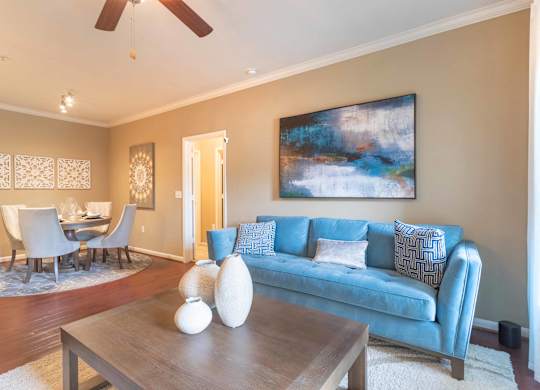 a living room with a blue couch and a coffee table at Century South Shore, League City, TX