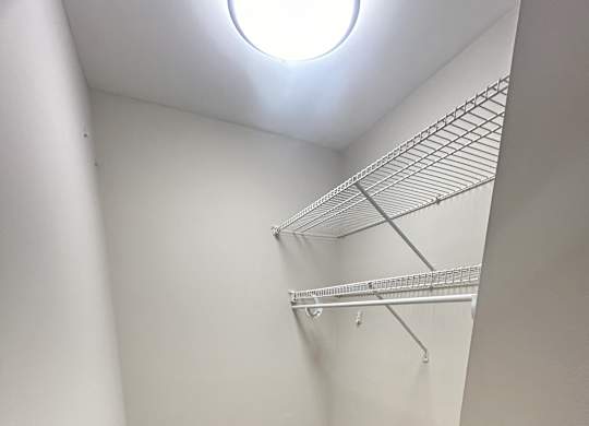 a walk in closet with a white wall and wood flooring at Briarcliff at Quechee Apartments, Quechee, Vermont