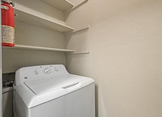 A white washing machine is in a small laundry room.