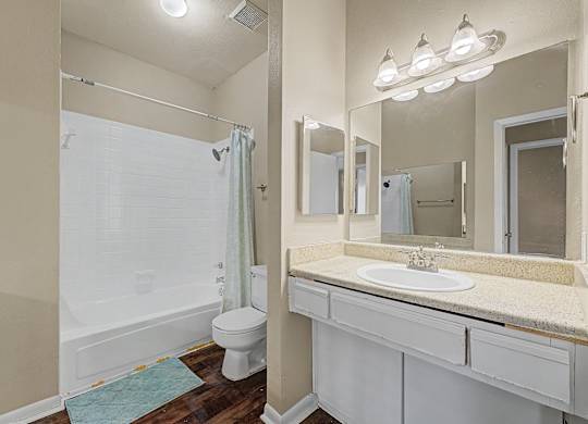 A white bathroom with a toilet, sink, and shower.