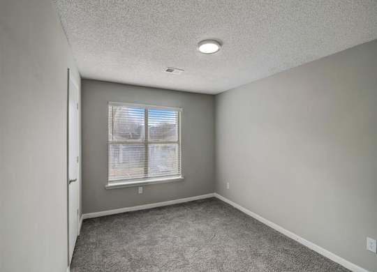 an empty room with a window and carpet at The Sapphire, Decatur, 30035