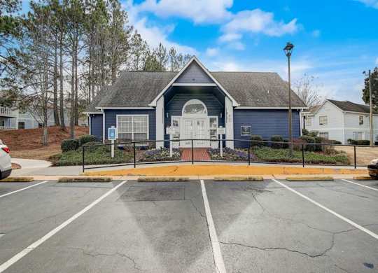 an empty parking lot in front of a blue house at The Sapphire, Decatur, GA
