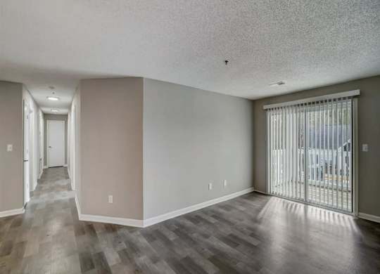 a living room with a sliding glass door to a balcony at The Sapphire, Georgia, 30035