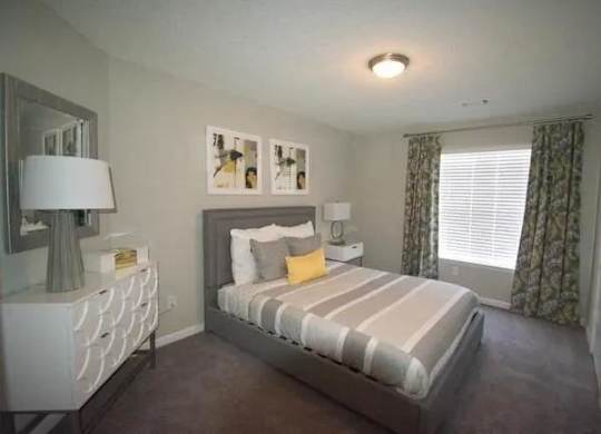 a bedroom with a bed and a dresser and a window  at The Sapphire, Georgia, 30035