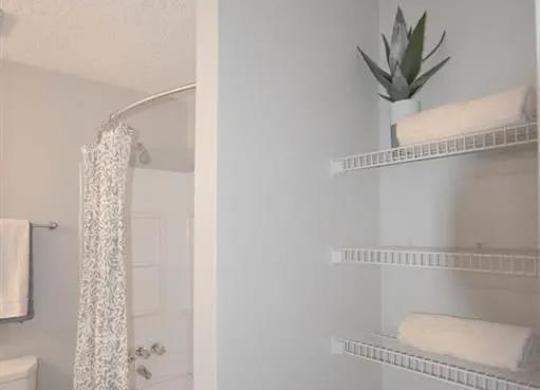 a white bathroom with a shower and a toilet at The Sapphire, Decatur, 30035