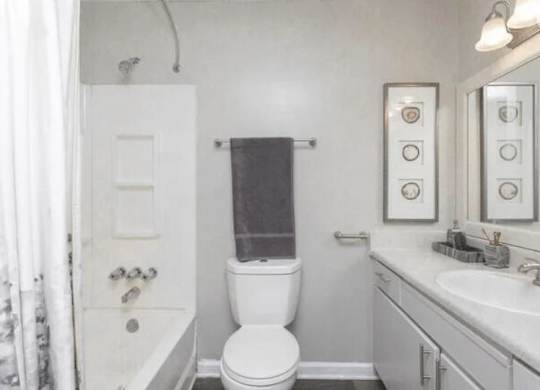 a white bathroom with a toilet and a sink at The Sapphire, Decatur, GA, 30035