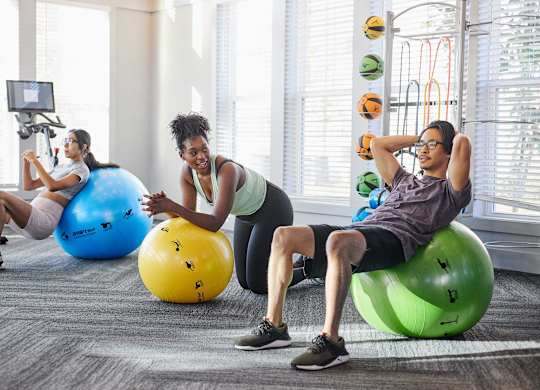 people working out on exercise balls in a gym at Century Mundy Mill Apartments, Oakwood, Georgia