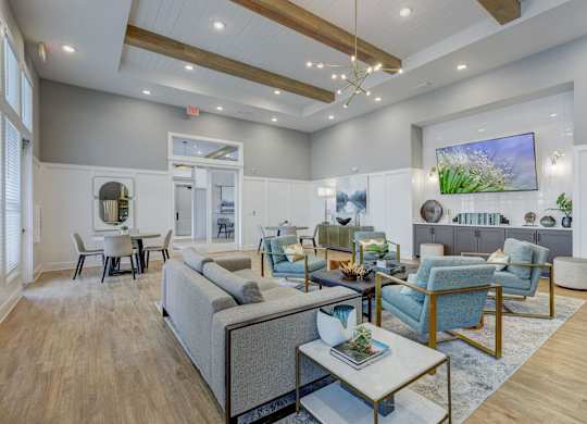 a living room with couches and chairs and a table at Century Mundy Mill Apartments, Oakwood, GA 30566