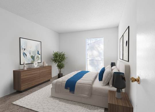 A bedroom with a bed, nightstand, and a plant. at Grove at St. Andrews, Columbia, SC