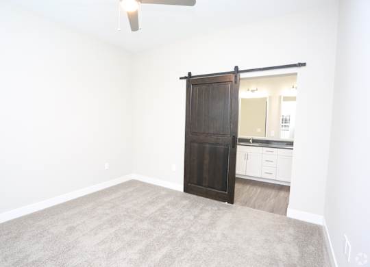an empty living room with a wooden sliding door to a bathroom at Century Baxter Avenue, Kentucky, 40204