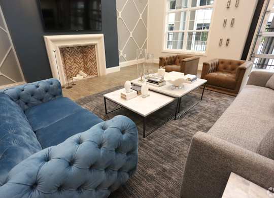 a living room with couches and chairs and a fireplace at Century Baxter Avenue, Louisville, 40204